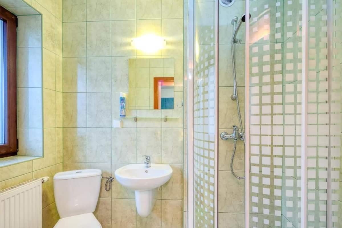 A bathroom with a toilet, sink, and glass-enclosed shower.