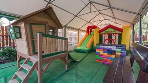 A play area with a wooden playhouse, a slide, and colorful blocks. - Dom Wczasowy Na Kamiencu (Białka Tatrzańska)