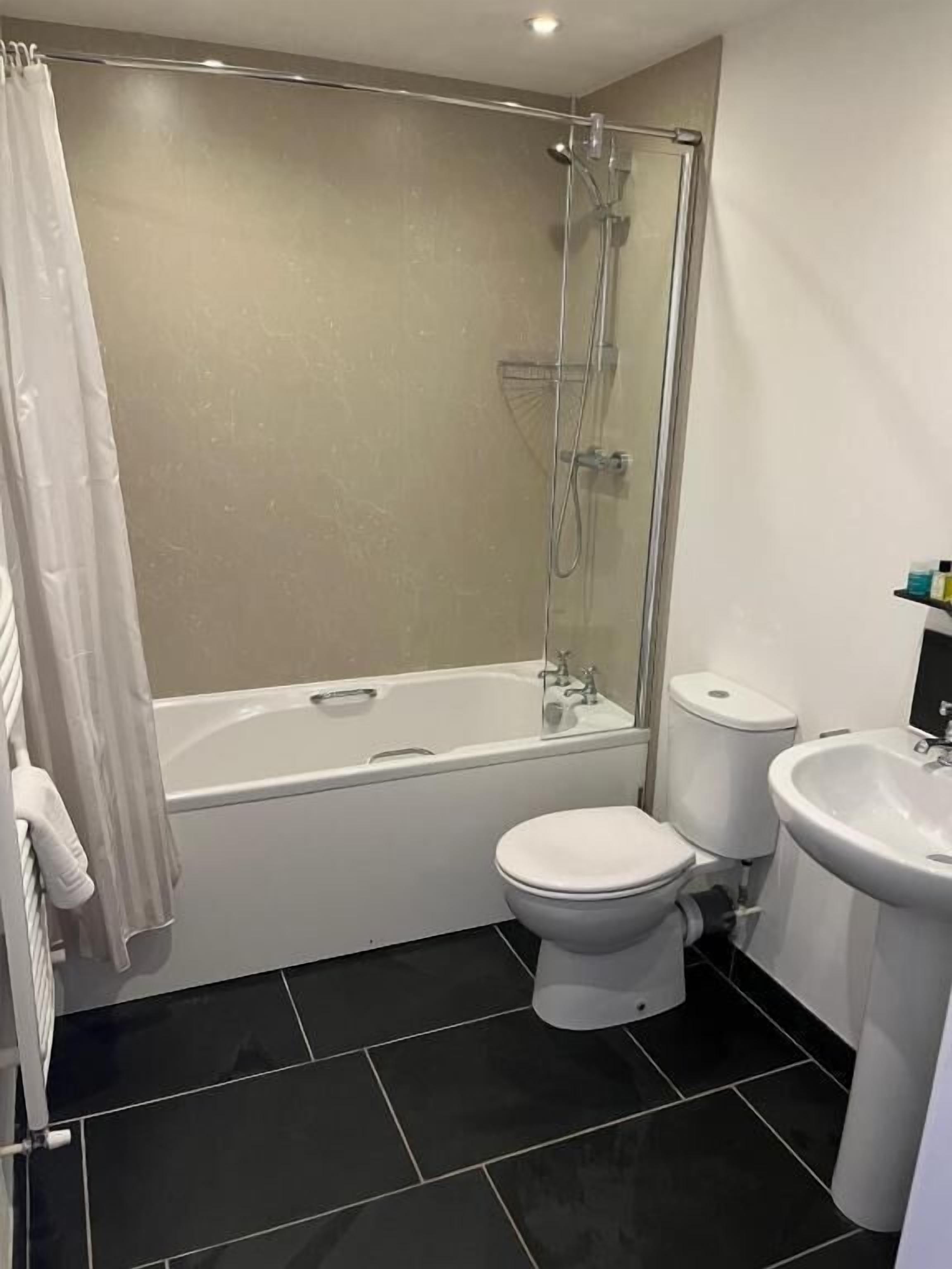 A bathroom with a bathtub, toilet, and sink.