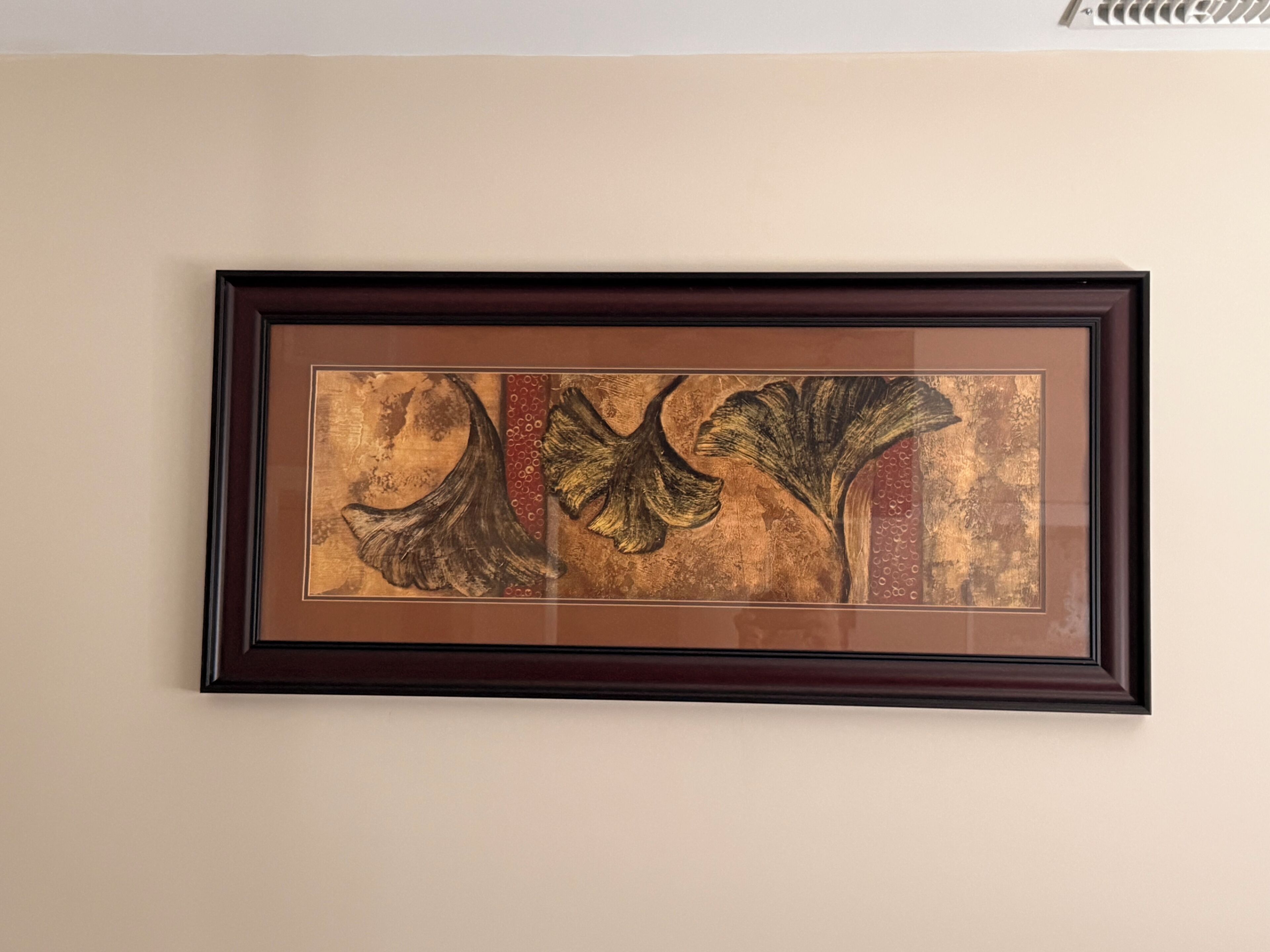 A framed artwork with abstract designs on a wall.