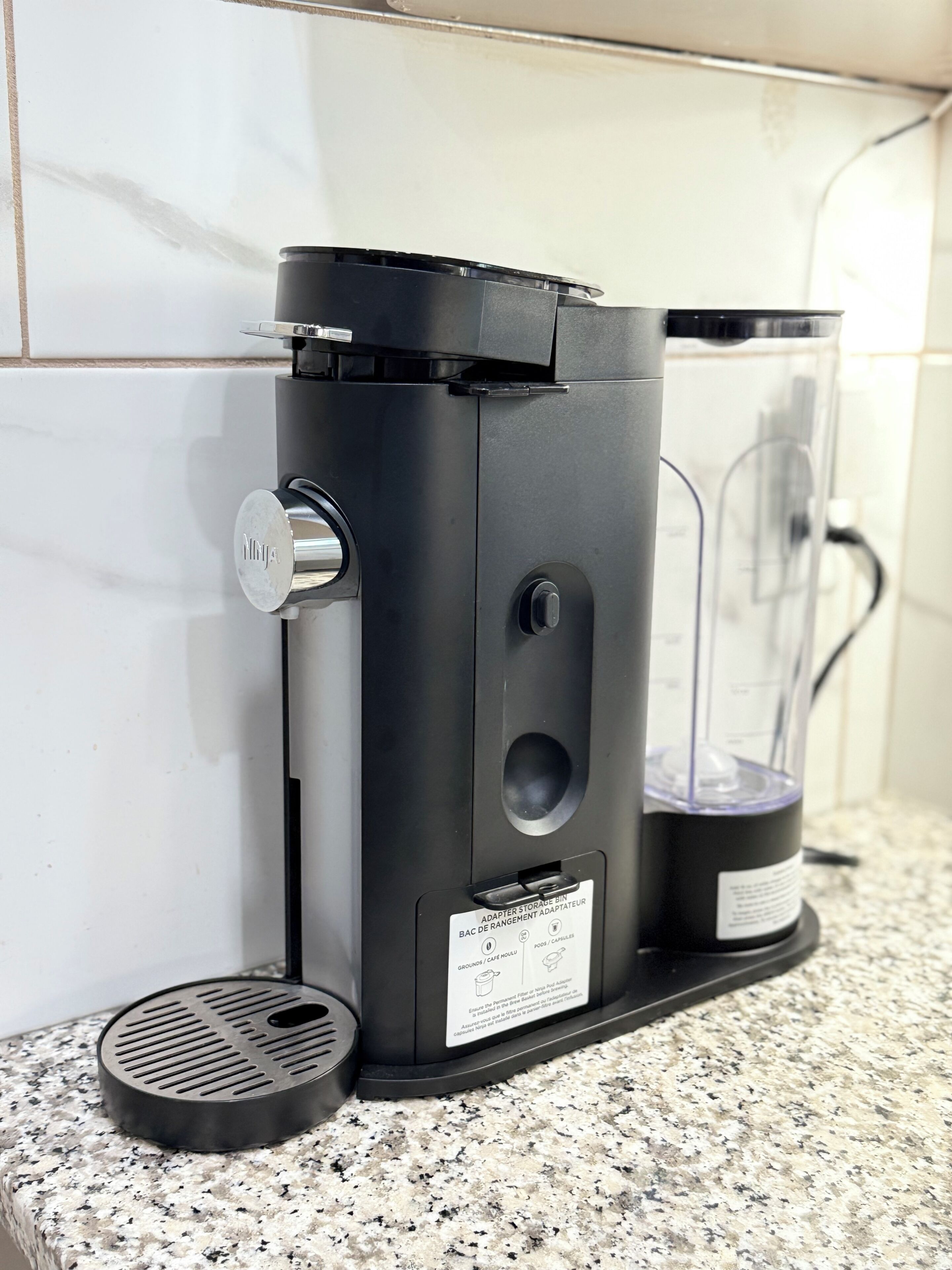 Máquina de café com adaptador para depósito, sobre uma bancada de granito.