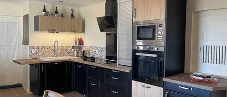 A modern kitchen with a microwave, oven, and sink.