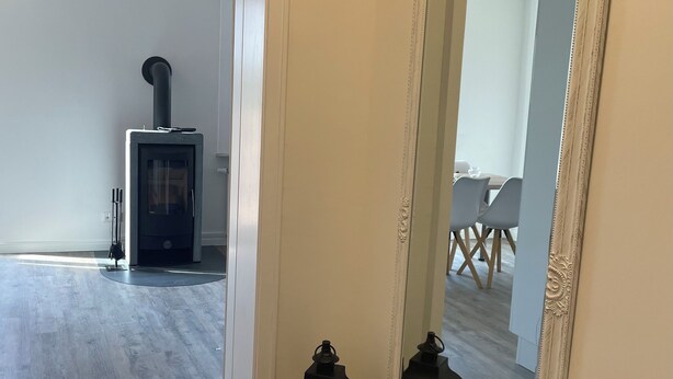 A room with a large mirror, a small table with candles, and a visible fireplace in the background. - Apartment Kaiserperle at Haus Urvasi - Seaside-Flair with sauna and fireplace (Lübeck)