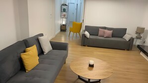 Ein modernes Wohnzimmer mit zwei Sofas, einem Couchtisch und einem Essbereich mit einem Stuhl.