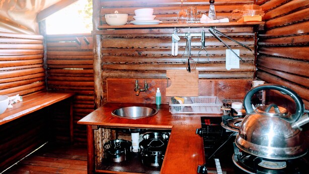 A compact kitchen with wooden walls, a sink, a kettle, and basic utensils. - Kosi Bay Mouth Utshwayelo Lodge and Camp (Mahlungulu)