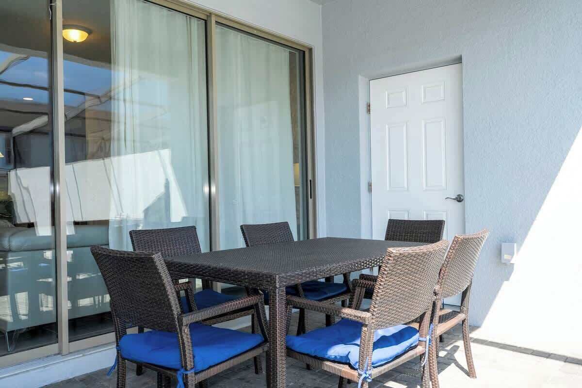 A dining area with a table and chairs, a sliding glass door, and a white door.