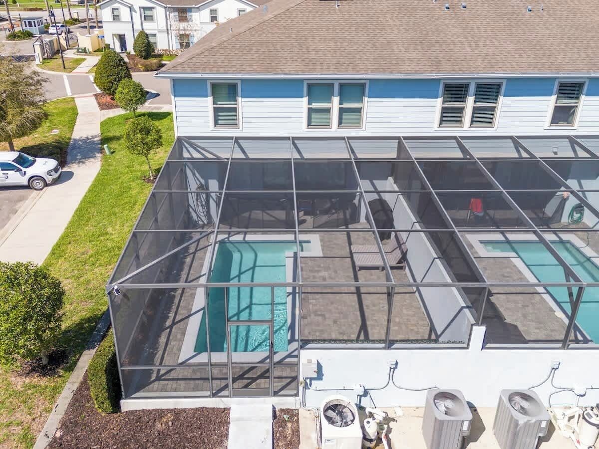 A residential building with a rooftop pool enclosed by a glass barrier.