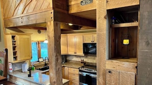 A rustic kitchen with wooden cabinetry, a built-in stove, and a hanging lantern. - 4-bedroom house with Hottub in charming Breckenridge (Breckenridge)