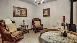A room with a leather sofa, a wooden chair, a small table, a wine glass, and a wine bottle. - 4-bedroom house with Hottub in charming Breckenridge (Breckenridge)