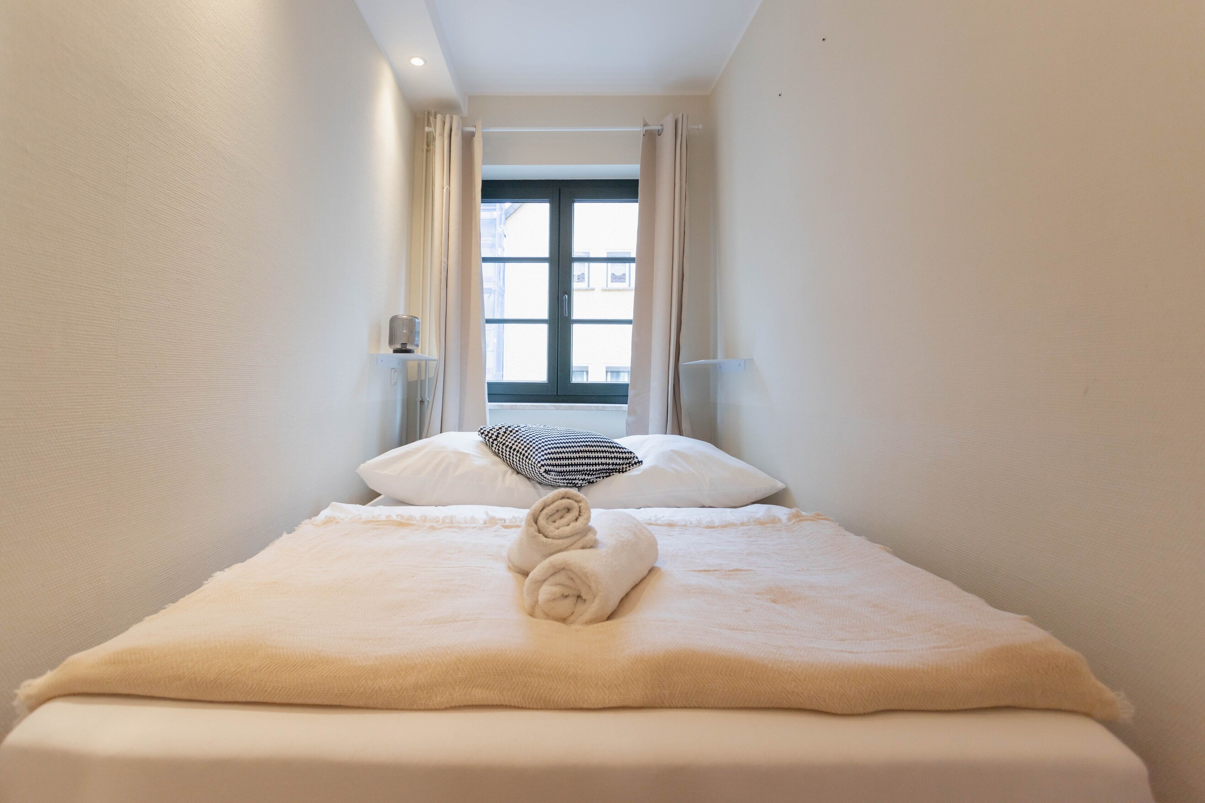 Una habitación de hotel con cama, ventana y vistas al exterior.
