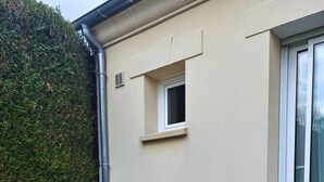 Rakennuksessa on ikkuna, ovi ja pieni ikkuna oven yläpuolella.