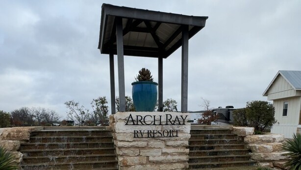 Un escalier en pierre mène à un belvédère sur lequel est apposée une pancarte indiquant : « Archray RV Resort ».