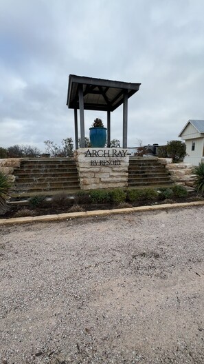 A stone staircase leading to a gazebo with a sign reading 'Archray RV Resort.' - 1 Bedroom and Loft- The Daisy Tiny Home, Relaxing and Peaceful Escape (Fredericksburg)