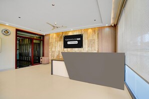 Ein Empfangsbereich mit einem Schild, das 'Townhouse Oak' zeigt, einem Deckenventilator und einer Holzwand.