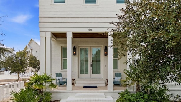A white building with a porch, numbered 66, and two chairs outside. - 66 Parks Edge (Orange Beach)