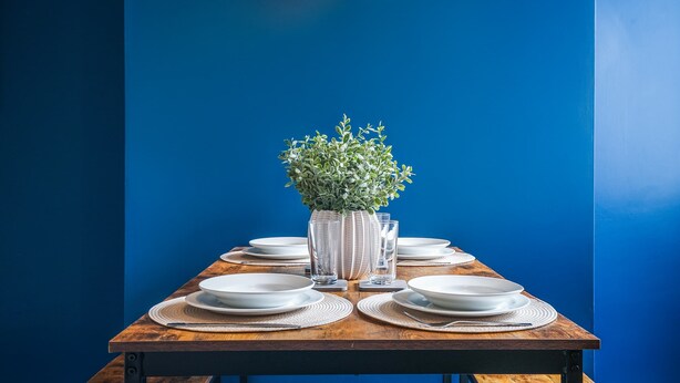 A dining table set with plates, glasses, and a vase with a plant. - Central Grimsby House w/ Free Parking & Garden (Grimsby)