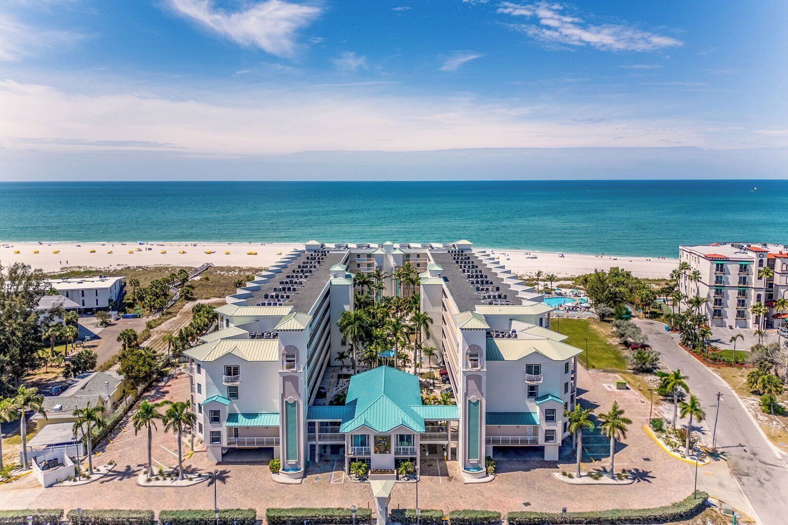 Un resort con diversi edifici, una spiaggia e una vista libera sull'oceano.