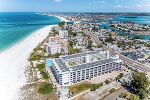 Et kysthotel med udsigt over stranden, flere swimmingpools og parkeringsplads.