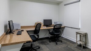 A small office space with two desks, two chairs, a whiteboard, and a small table. - Sunset Vistas Getaway (Treasure Island)