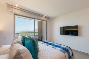 A bedroom with a bed, a TV, a balcony with a view, and a window. - U-GO Santa Marina Exclusividad y Mar (Santa Marta)