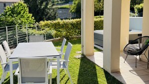 Een terras met een tafel en stoelen, een zwarte stoel en uitzicht op het landschap.