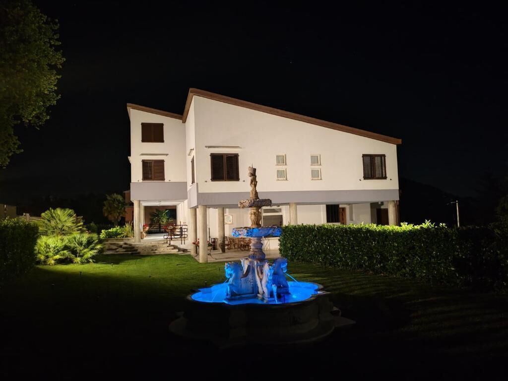 Un edificio de dos pisos con una fuente al frente.