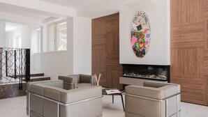 Una sala moderna con chimenea, sofás de cuero y un revestimiento de pared de madera.