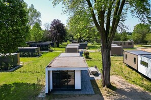 A residential area with modern, compact houses, each with a flat roof and a small front yard. - Cube XL 37 | 4 persoons chalet in Zennewijnen (Zennewijnen)