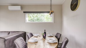 Comedor con una mesa redonda de madera dispuesta para cuatro personas, rodeada de sillas acolchadas.