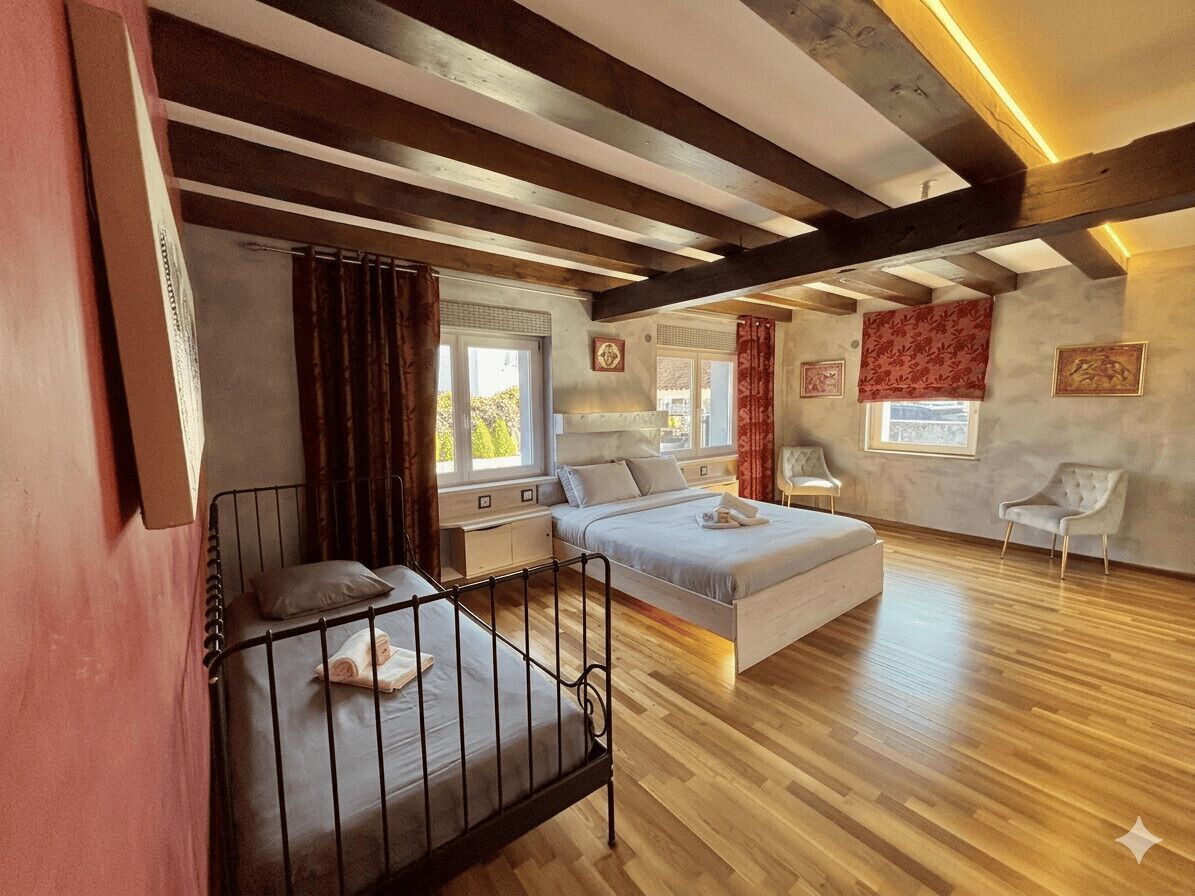 Een slaapkamer met een bed, een klein bureau, een stoel en een raam.