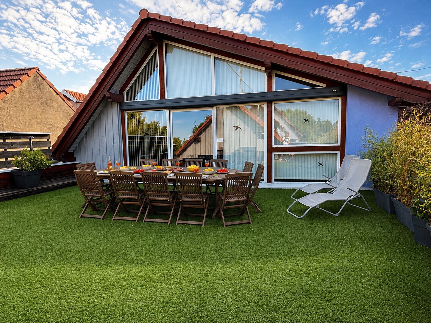 Une maison moderne dotée d’un coin repas, d’un patio couvert et offrant une vue sur le ciel.