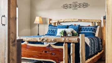 A rustic wooden bed with a unique design, a bedside lamp, and decorative wall art.
