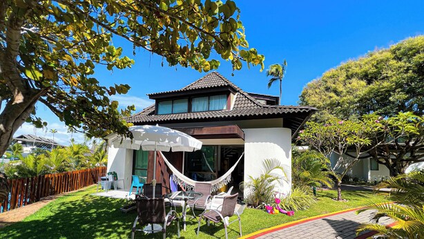 A two-story house with a tiled roof, a hammock, outdoor furniture, and a paved driveway. - Bangalô à Beira-Mar - Piscina Gigante (Ipojuca)