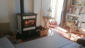 A cozy living room with a fireplace, a sofa, a small table with a lantern, and a bookshelf. - Enter the wonderful world of nature and the stars of Morvan (Arleuf)