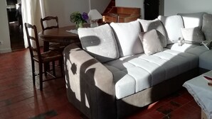 A living room with a sofa, chairs, a table, and a staircase. - Enter the wonderful world of nature and the stars of Morvan (Arleuf)