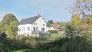 A white house with blue shutters, surrounded by greenery and a clear sky. - Enter the wonderful world of nature and the stars of Morvan (Arleuf)