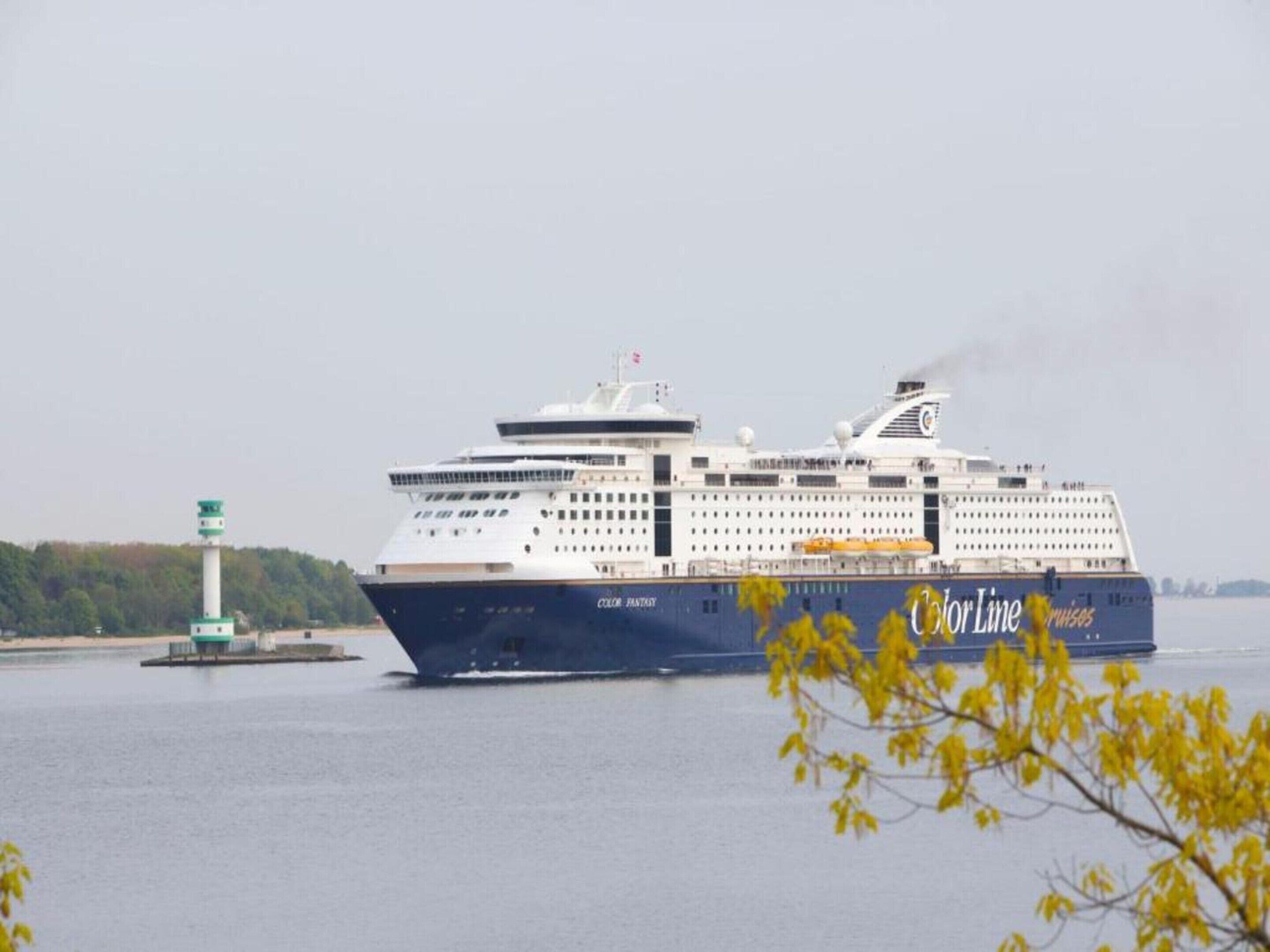 A large cruise ship with multiple decks and a prominent logo on its side.