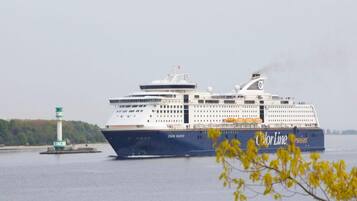 A large cruise ship with multiple decks and a prominent logo on its side.