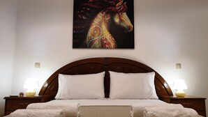 Une chambre dâhĂŽtel avec un grand lit, deux tables de chevet, un tableau accrochĂ© au mur et une moquette Ă motifs.