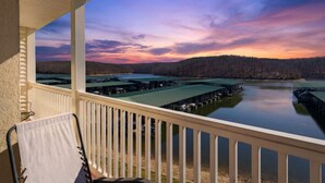 A balcony with a view of a dock and a lake at sunset. - Sunset Serenity - Lakeside Pool & Location! (Osage Beach)