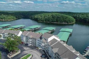 Ein Hotel mit Parkplatz, ein Gebäude mit Gründach und ein Gewässer mit Booten.
