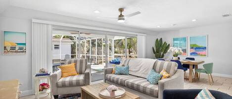 A spacious living area with a sofa, armchairs, a coffee table, and a dining table.