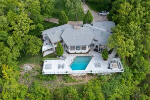 A large house with a swimming pool, surrounded by trees. - Vantage Point - Heated Pool, Hot Tub, & Views! (Sunrise Beach)