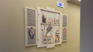 A hallway with a wall-mounted art piece featuring the word 'HOME' and decorative elements.
