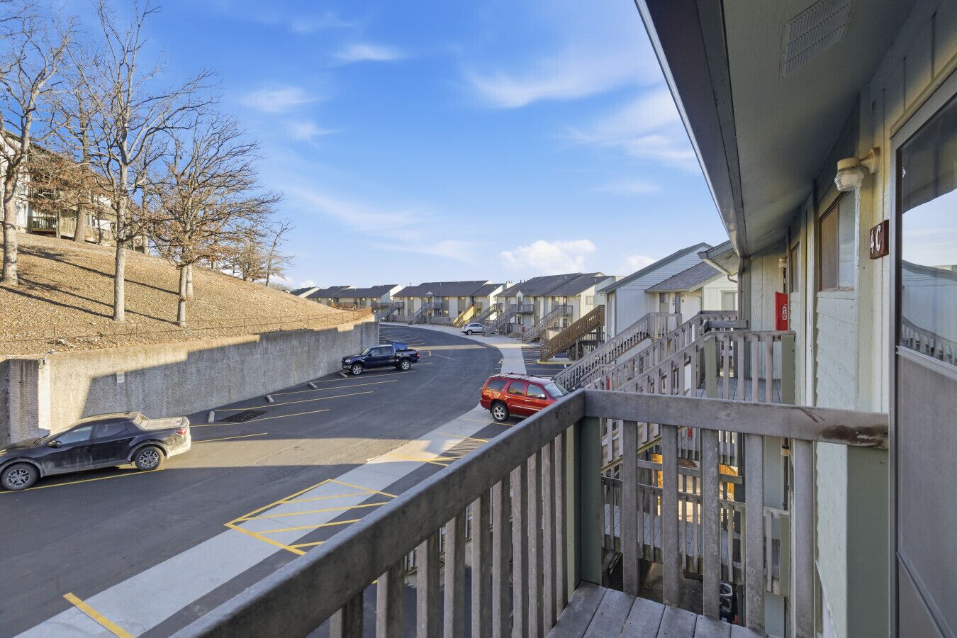 Rua residencial com casas, um carro e uma passarela para pedestres.