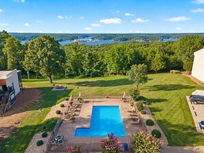 A backyard with a swimming pool, a lawn, and a view of a lake. - Graystone Getaway - Multiple pools! (Lake Ozark)
