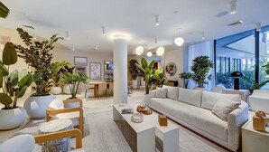 Un interior moderno con un sofá, una mesa de centro y plantas en macetas.