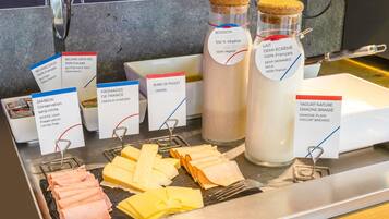 A cheese and yogurt display with labels indicating French origin and nitrite-free options.