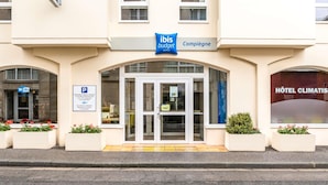 A hotel entrance with a sign for 'Ibis Boutique Hôtel Climatis' and a parking sign. - Ibis Budget Compiègne Centre-Ville (Compiegne)