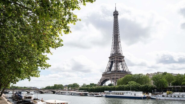 La Torre Eiffel con barcos amarrados a lo largo del río.